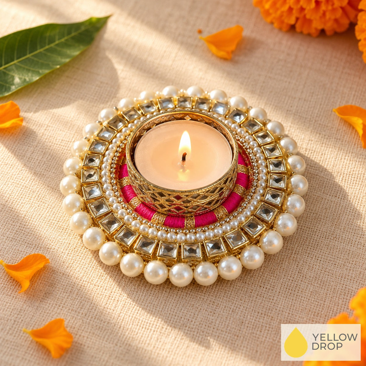 Pink Kundan Pearl tealight holder with lit tealight, kundan stones and pearls, marigold petals on linen