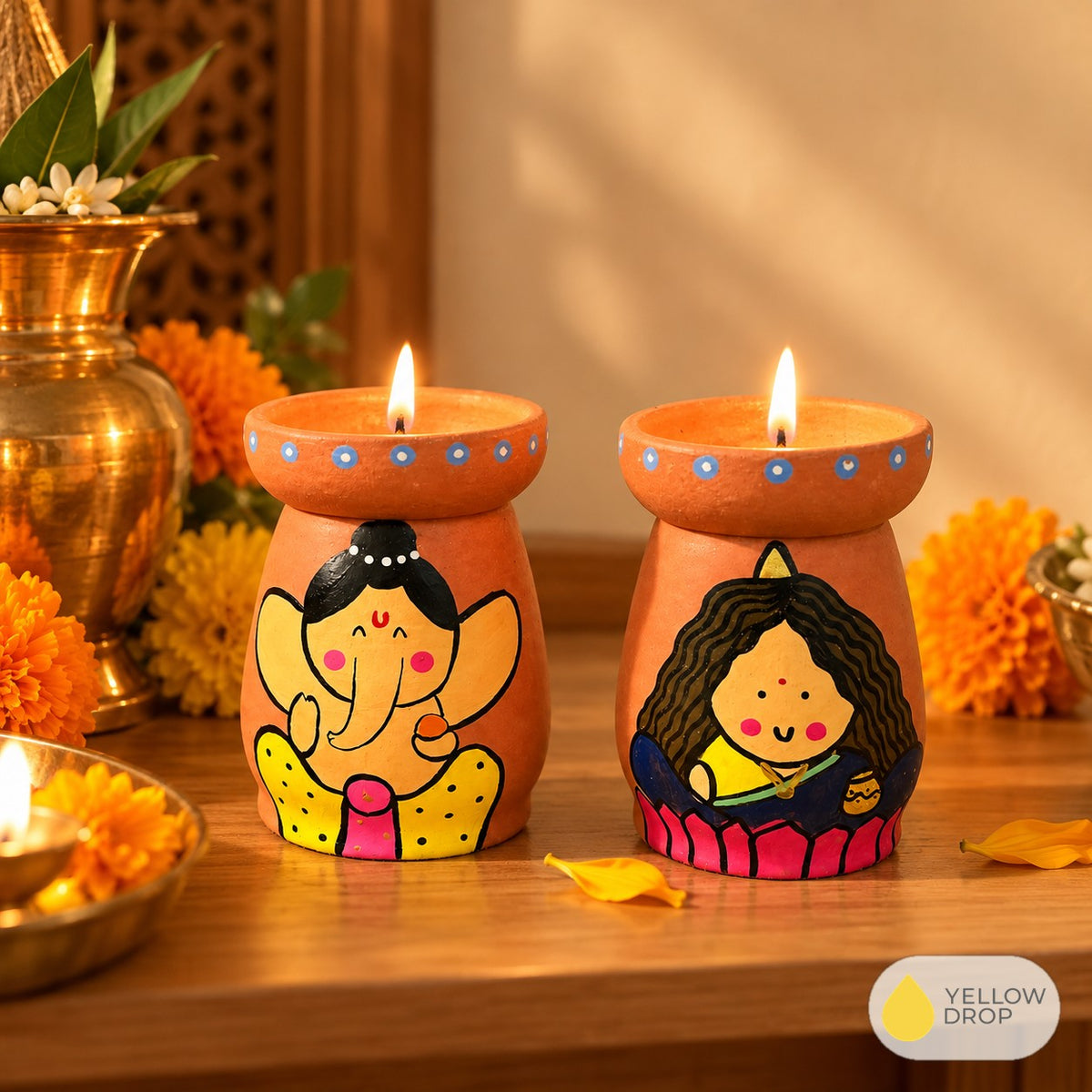 Ganesha and Lakshmi diya pots lit on a puja shelf