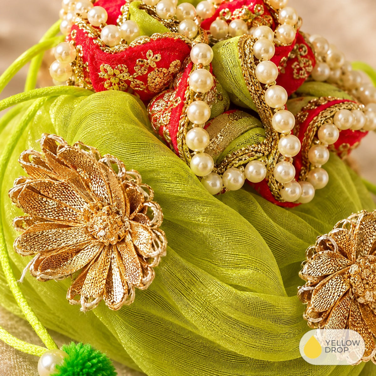 Close-up of gota flowers and pearl trim on green potli
