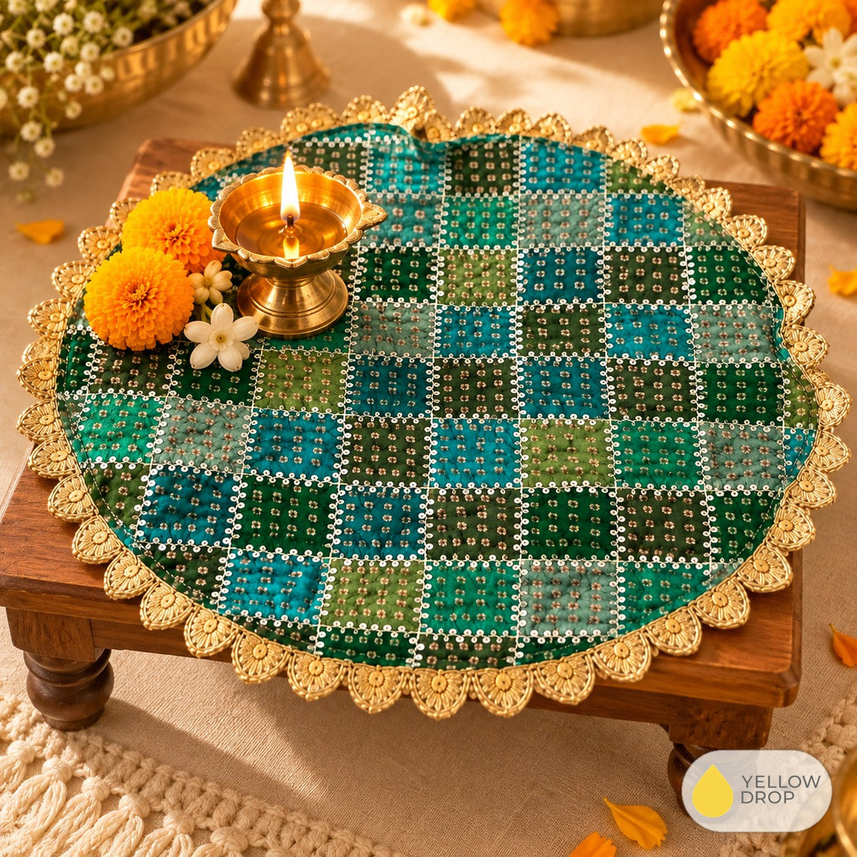 Green bandhani pooja cloth on a chowki with diya