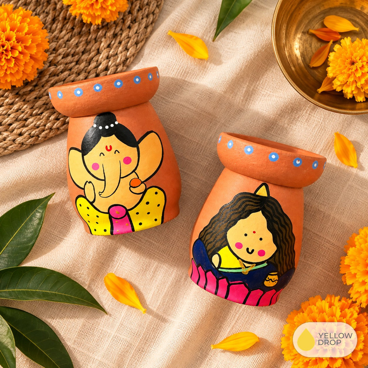 Ganesha and Lakshmi diya pots with marigolds
