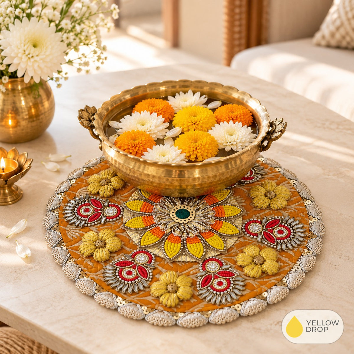 Beaded mandala mat under a brass urli with flowers