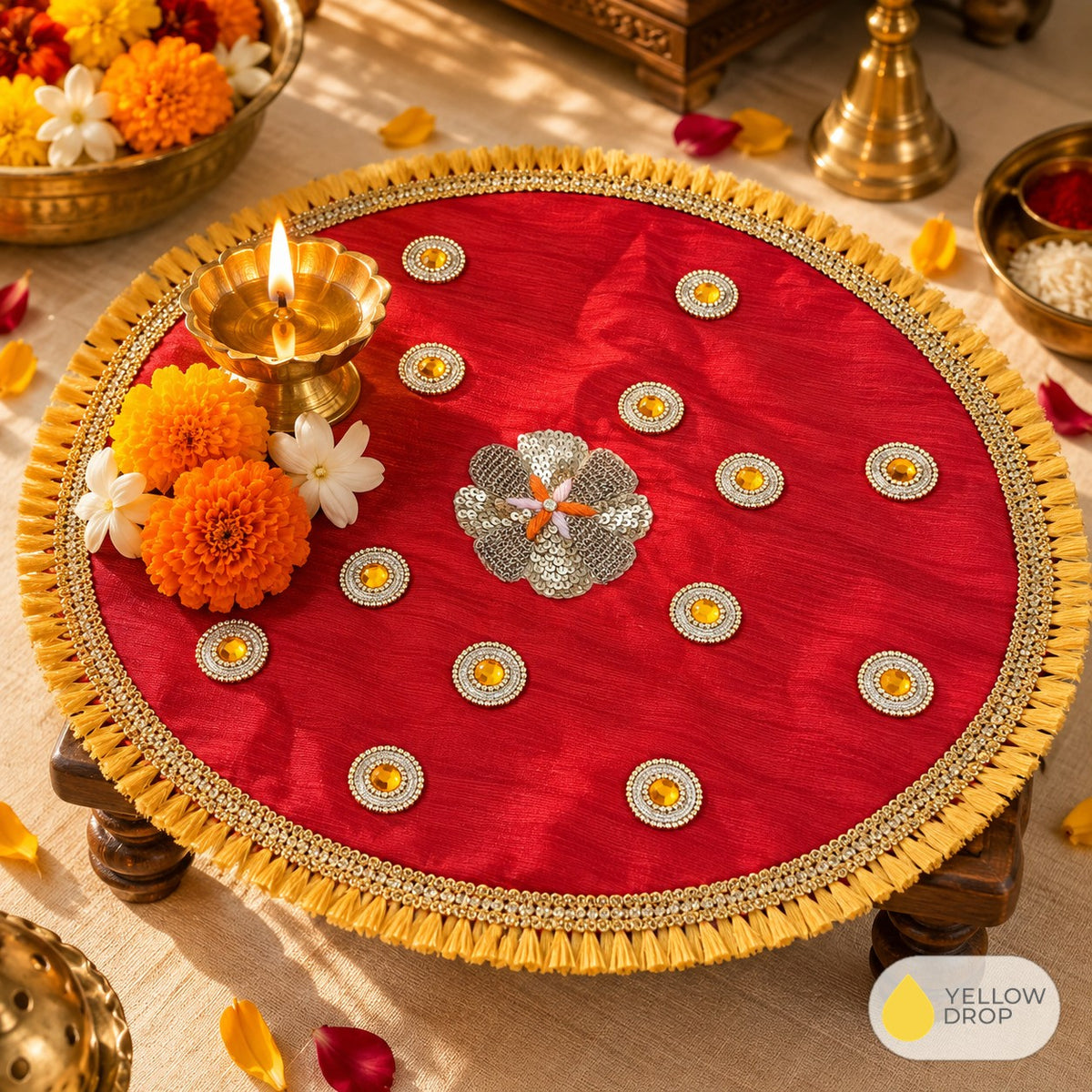 Red sequin pooja cloth on a chowki with diya