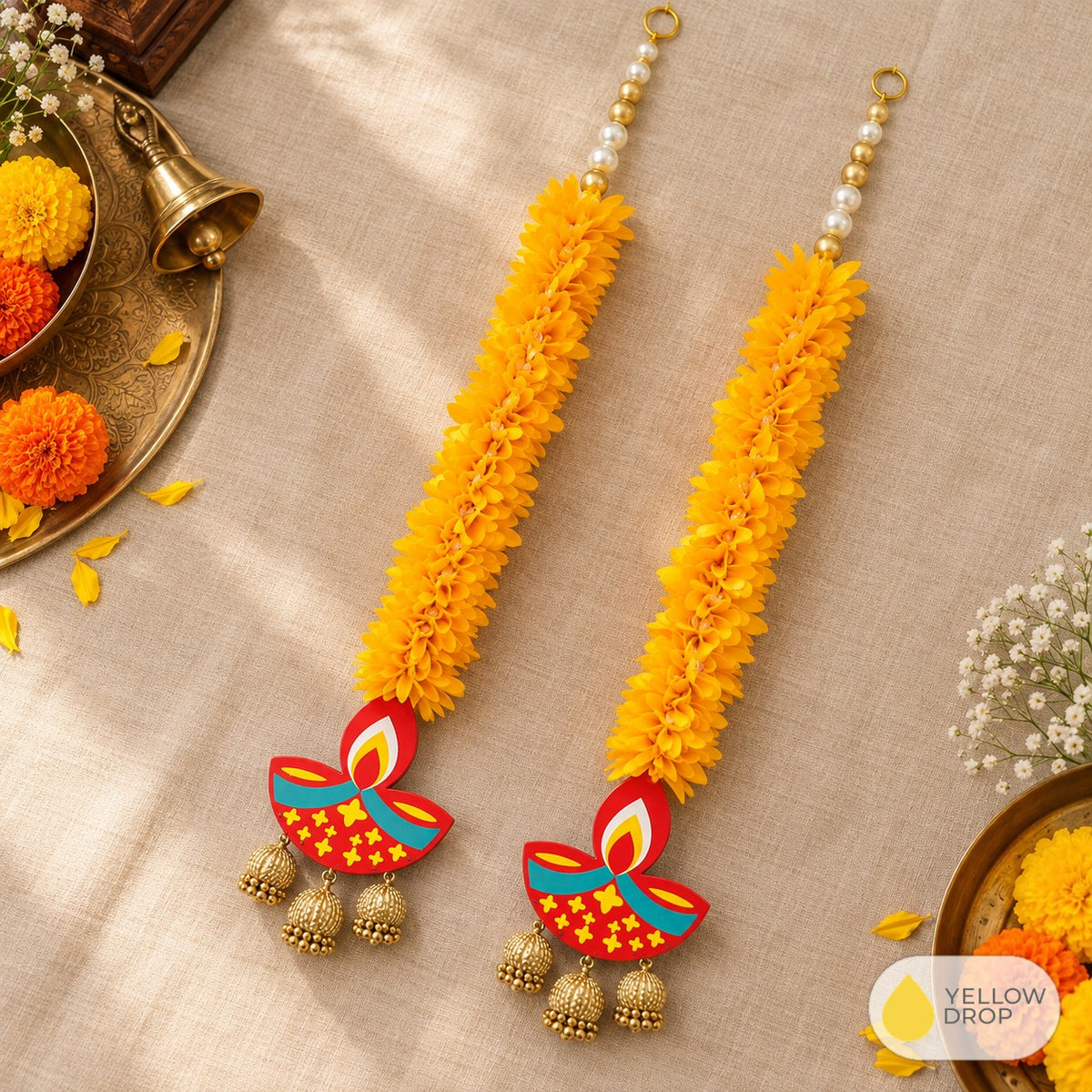 Marigold diya latkans flat-lay with brass bell
