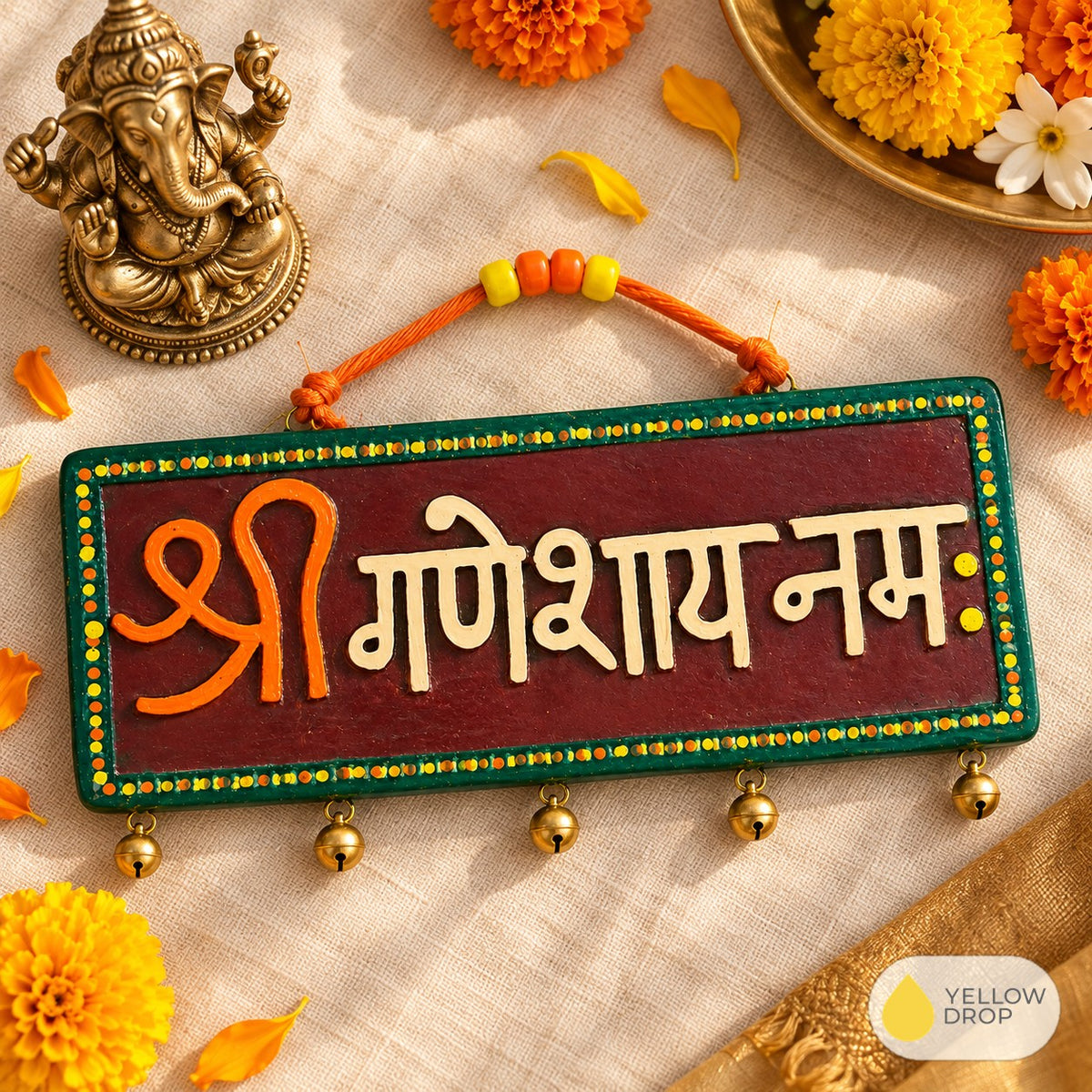 Ganesh plaque flat-lay with brass Ganesha and marigolds